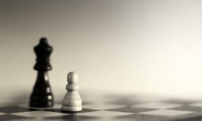 尘白禁区早期版本界面，游戏公测启动画面，玫红色调品牌视觉，废土城市背景下品牌LOGO醒目展示